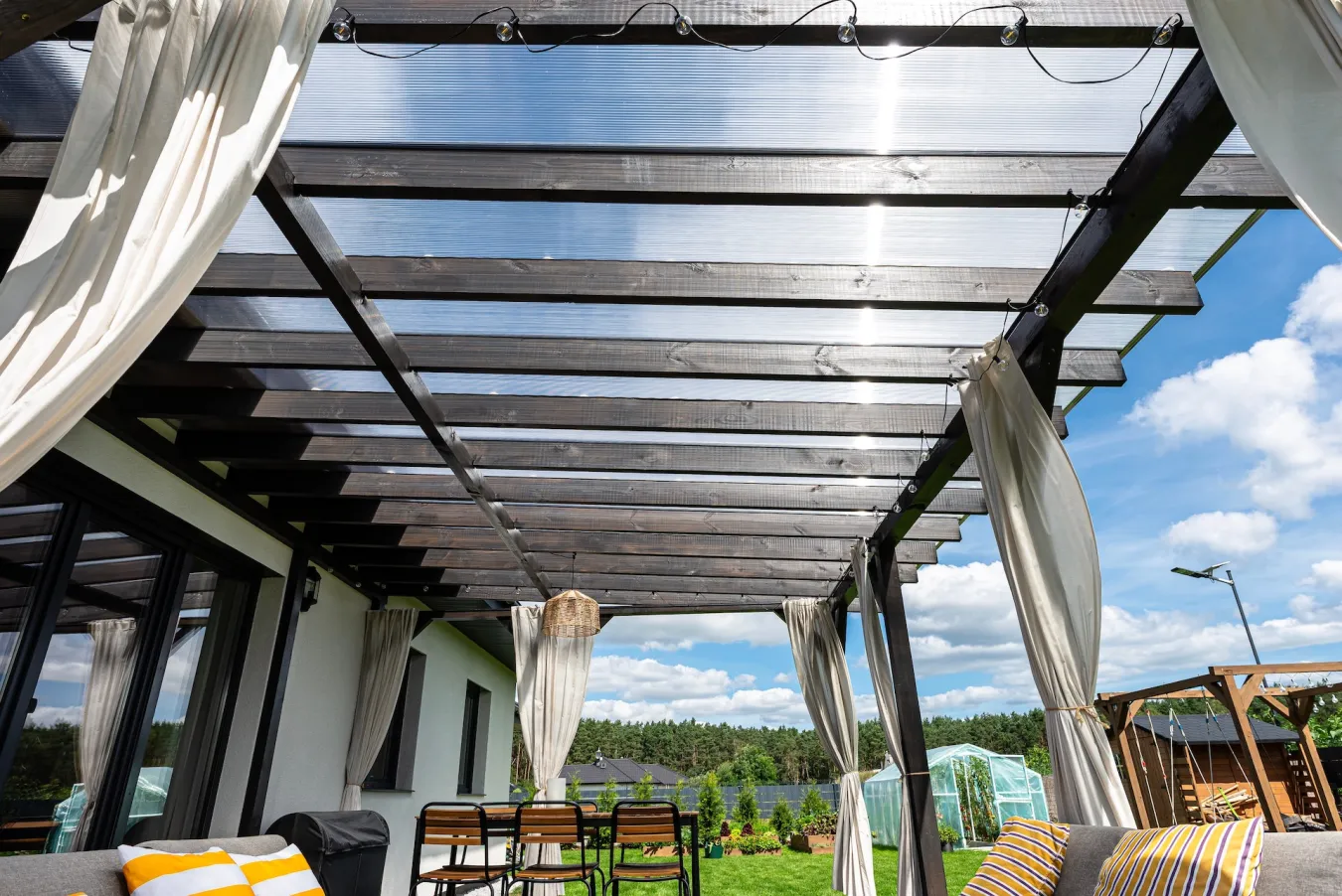 Drevená pergola s priehľadnou strechou na terase rodinného domu