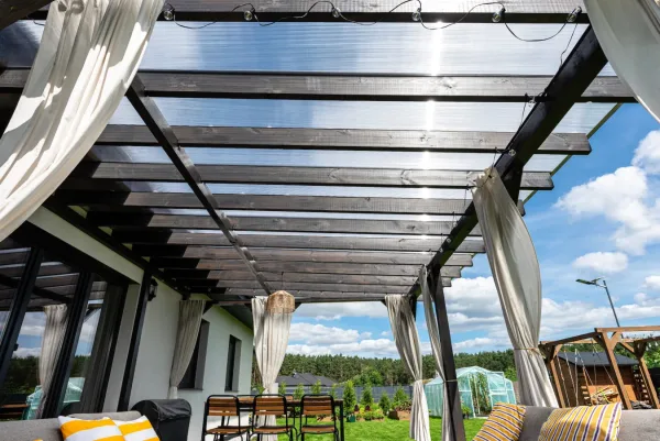 Drevená pergola s priehľadnou strechou na terase rodinného domu